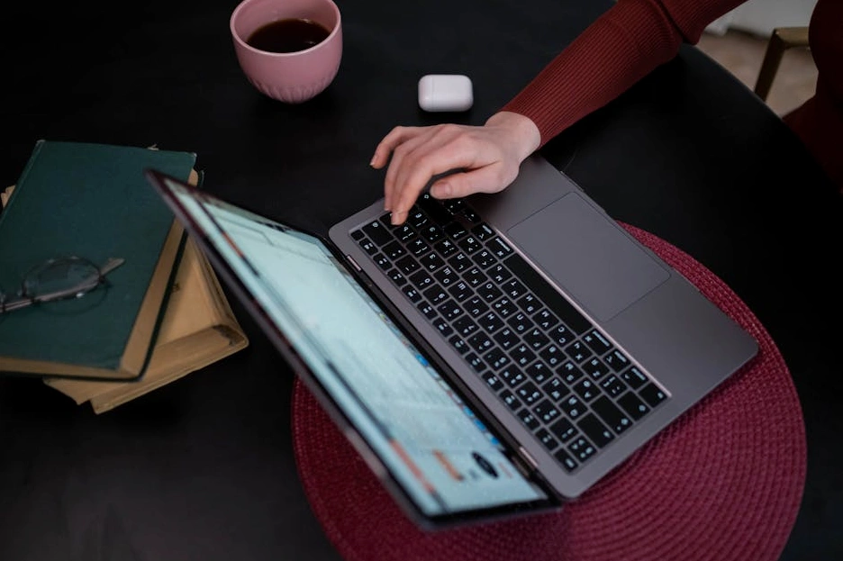 Osoba si zapisuje poznámky do deníku na pracovním stole.